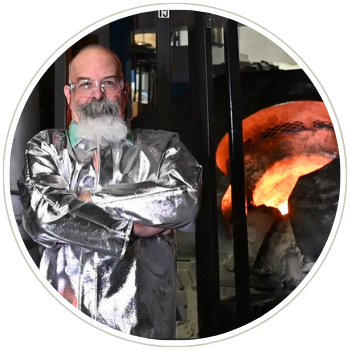 Bob the Melter in front of an induction furnace pouring molten metal